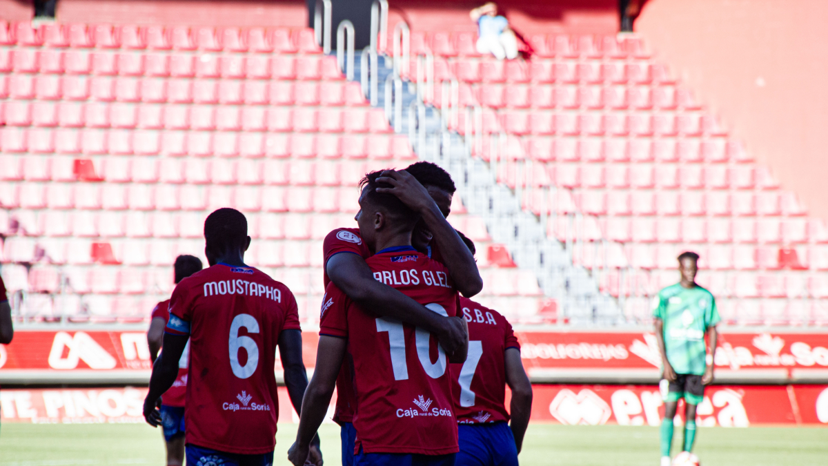 Carlos González, el mejor numantino ante el Atlético Paso, se abraza con Noé.