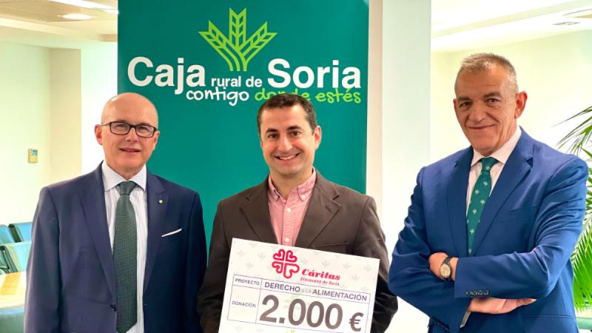 El responsable de Cáritas Soria con el cheque entregado por Caja Rural de Soria.