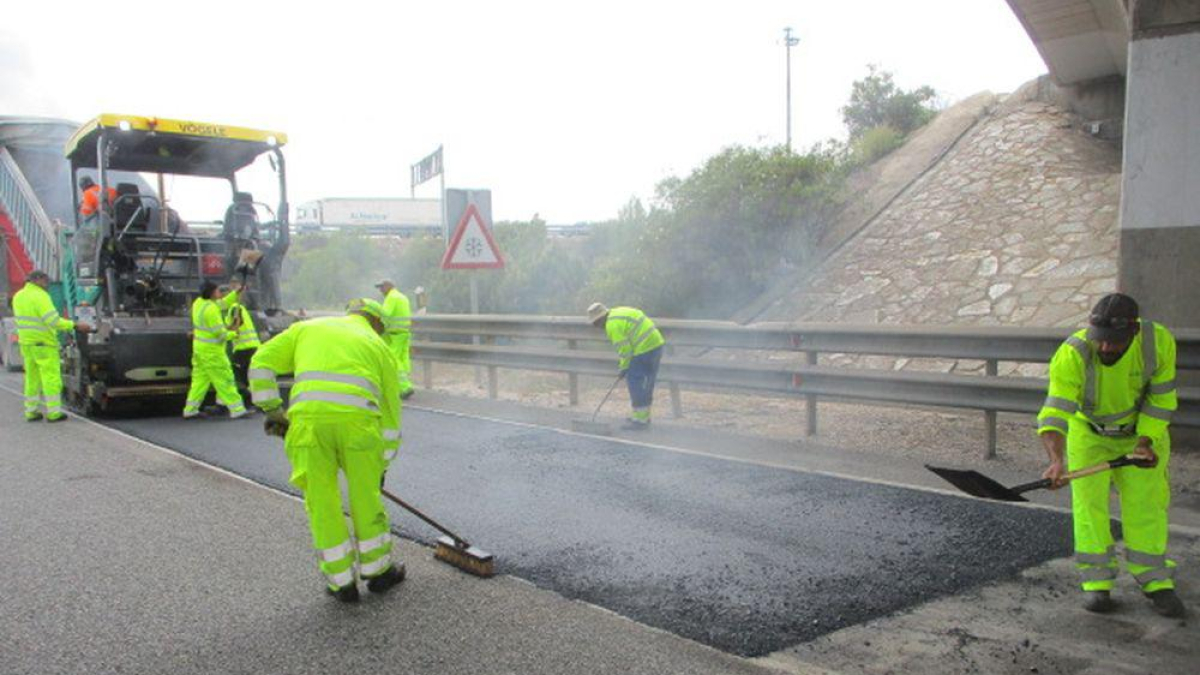 Varios operarios extienden asfalto en una carretera de Soria.