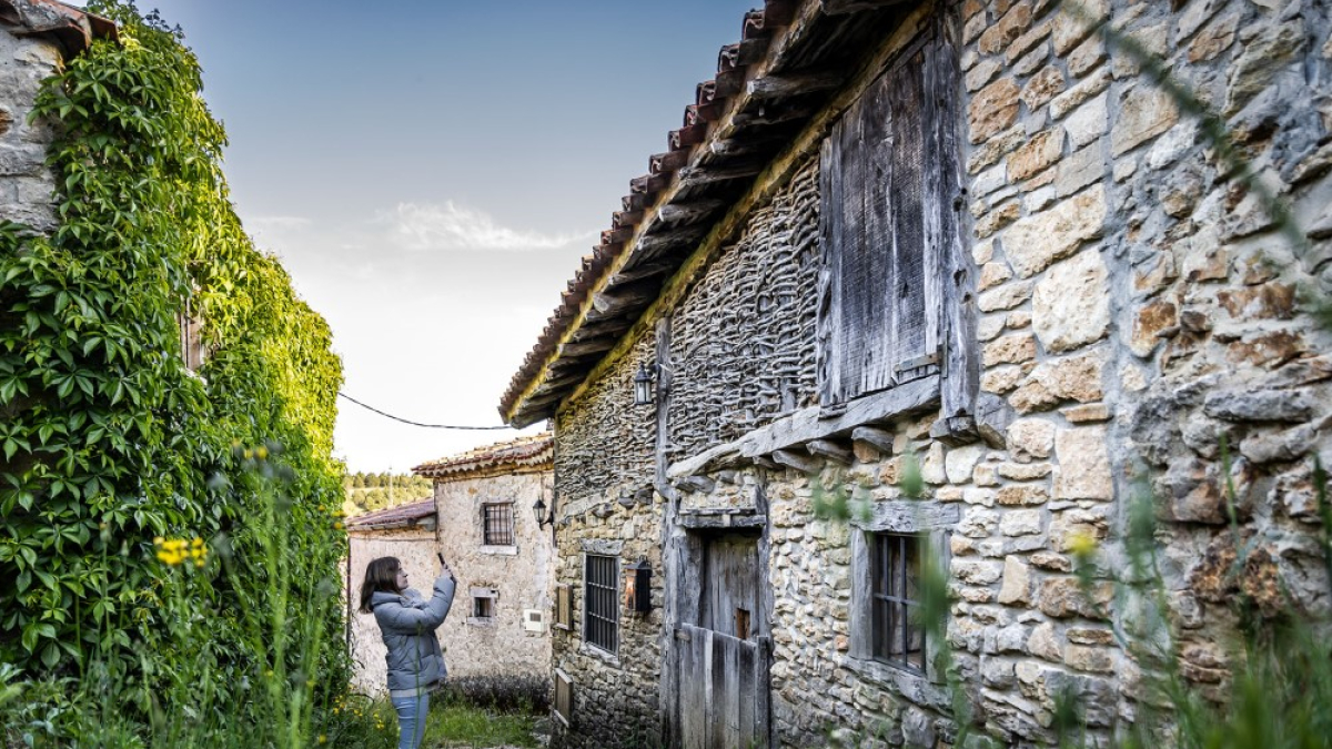 Una joven fotografía una de las viviendas tradicionales de La Cuenca.