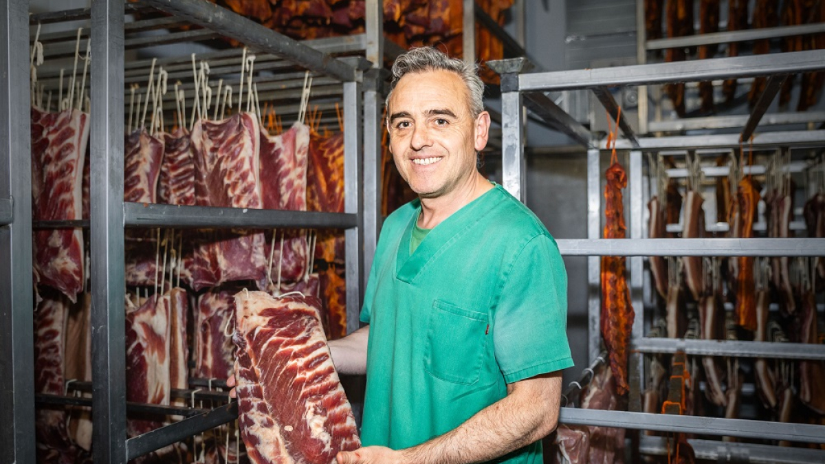 Santiago Alonso posa con una de las pancetas que preparan para hacer torreznos.