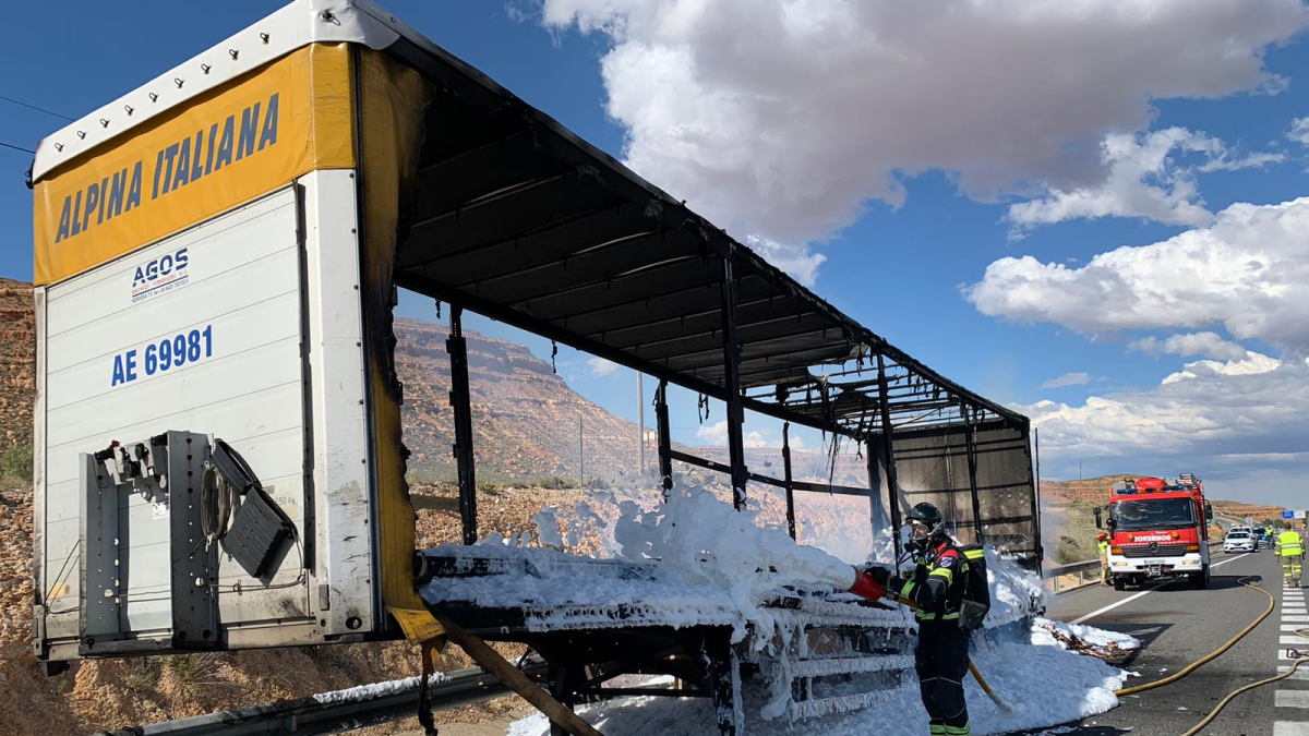 Los bomberos sofocan un incendio en un tráiler cargado con material de construcción.