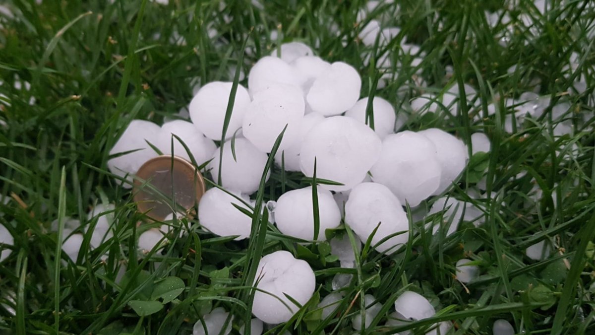 Las bolas de pedrisco de la tormenta comparadas con una moneda de euro.