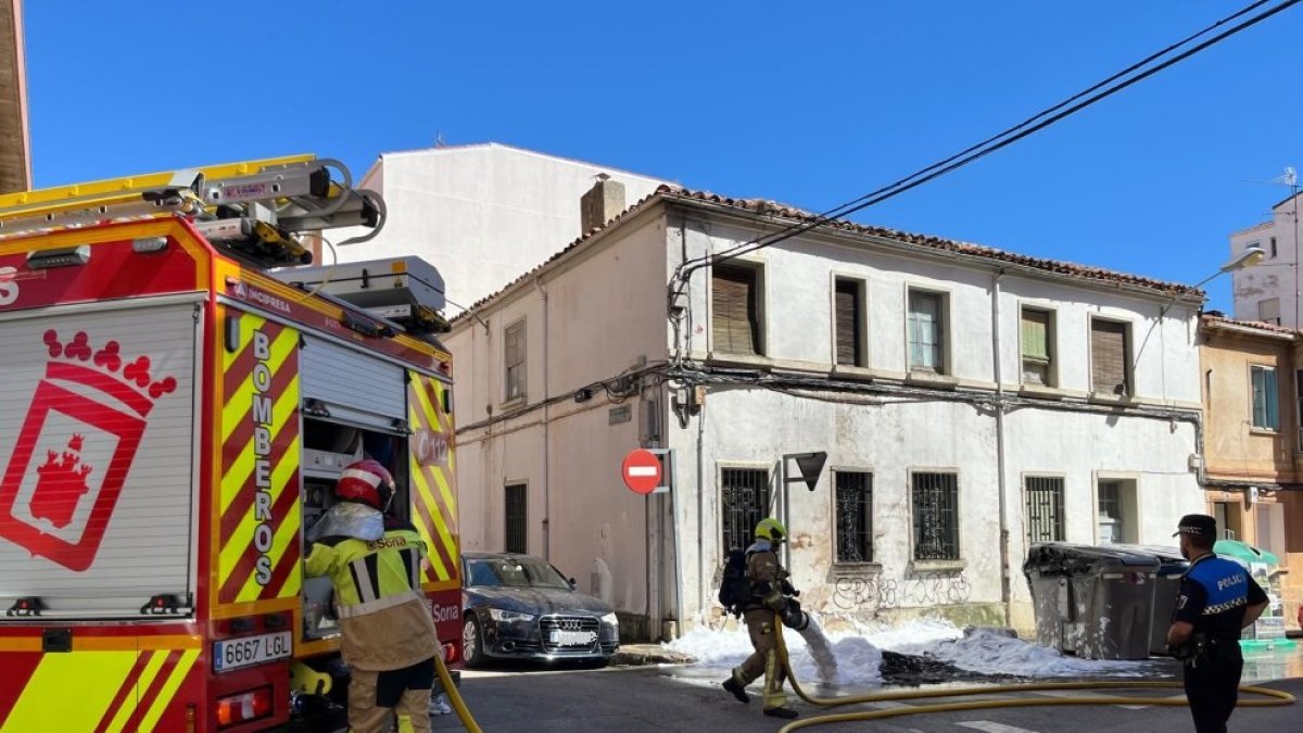 Los bomberos refrescan la zona tras apagar dos contenedores ardiendo en el barrio del Calaverón en la tarde del jueves festivo.