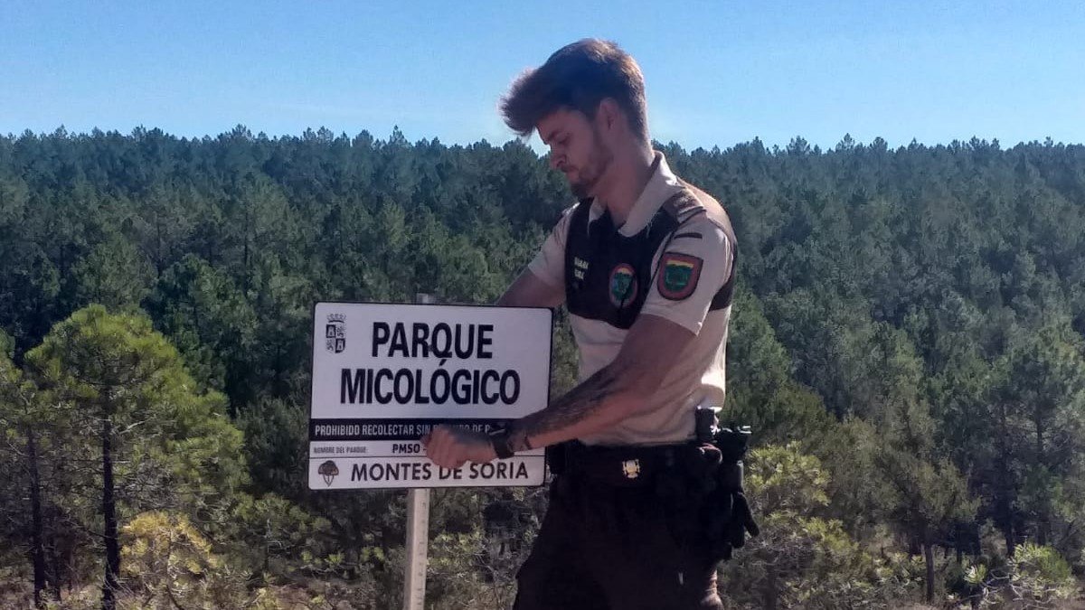 Un guarda coloca un cartel de Parque Micológico Montes de Soria.