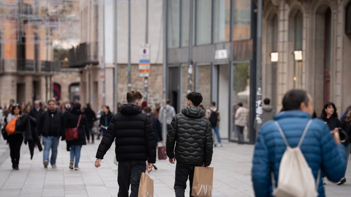 Archivo - Jóvenes sujetan bolsas con compras durante la campaña de Navidad de 2023.