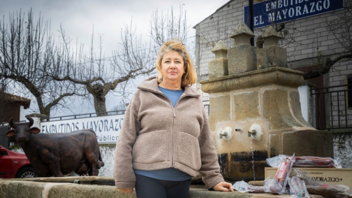 Pilar Escobar posa junto a algunos de los productos de Embutidos El Mayorazgo enfrente de su obrador.