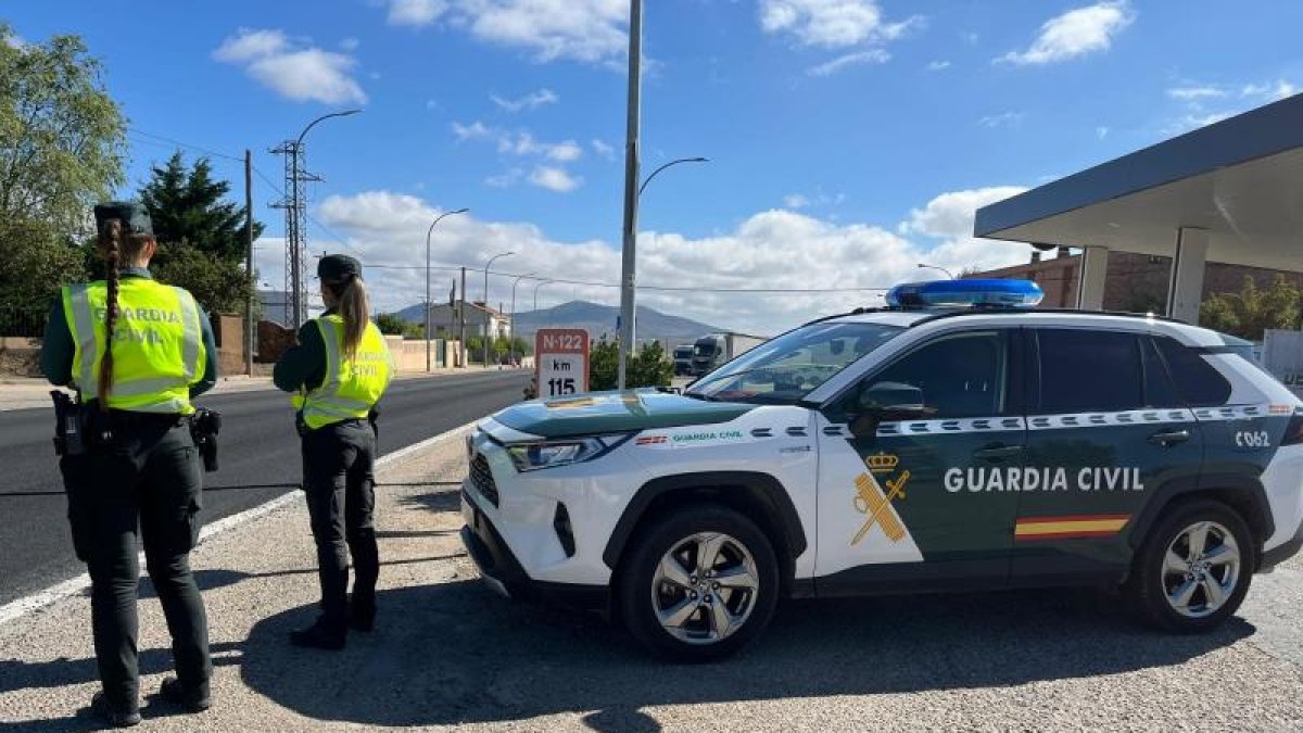 Dos agentes de la Guardia Civil junto a un vehículo del Cuerpo.