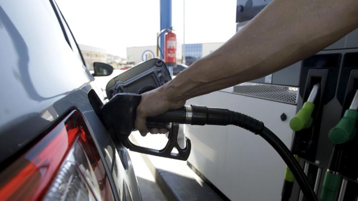 Conductor echando carburante al vehículo.