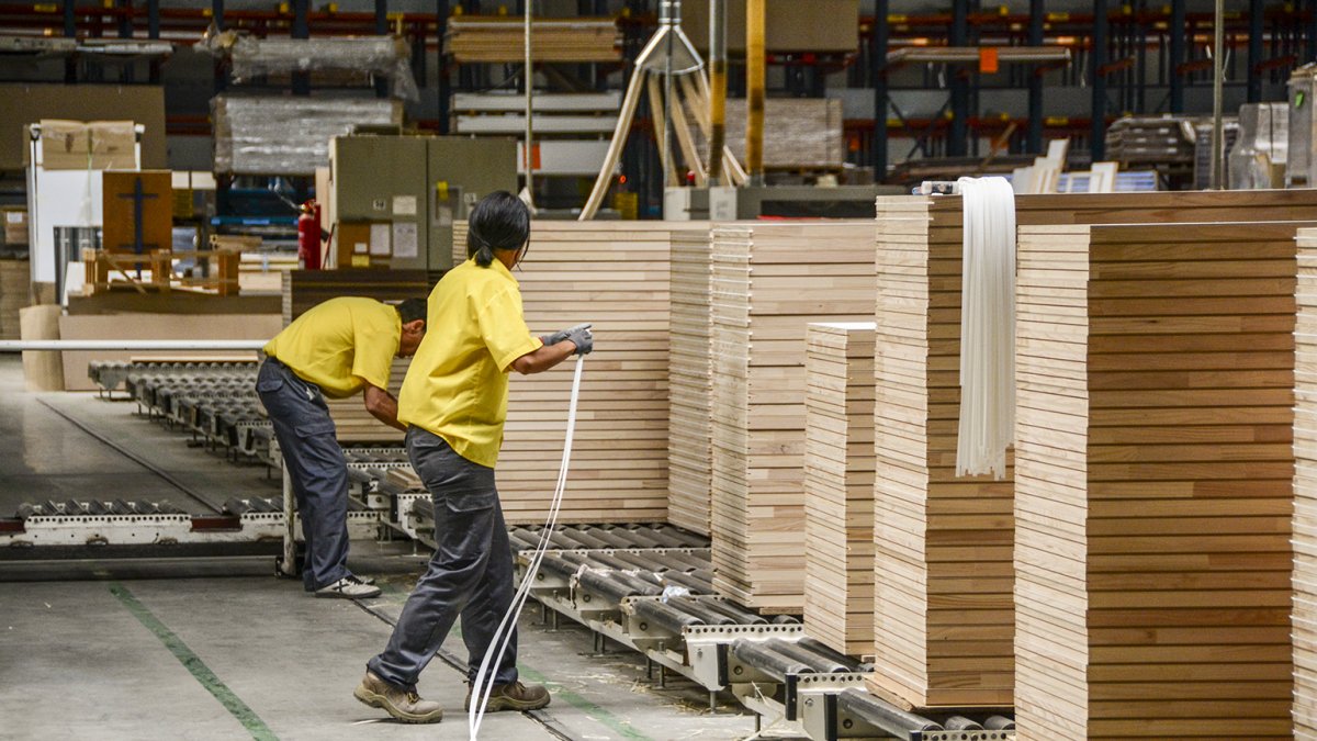 Vista del interior de la empresa Norma Doors de San Leonardo con dos trabajadores.