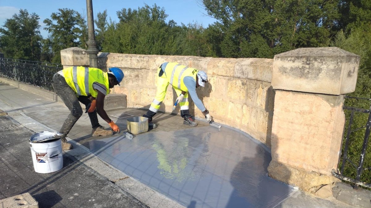 Operarios trabajando sorbe el puente de San Esteban.