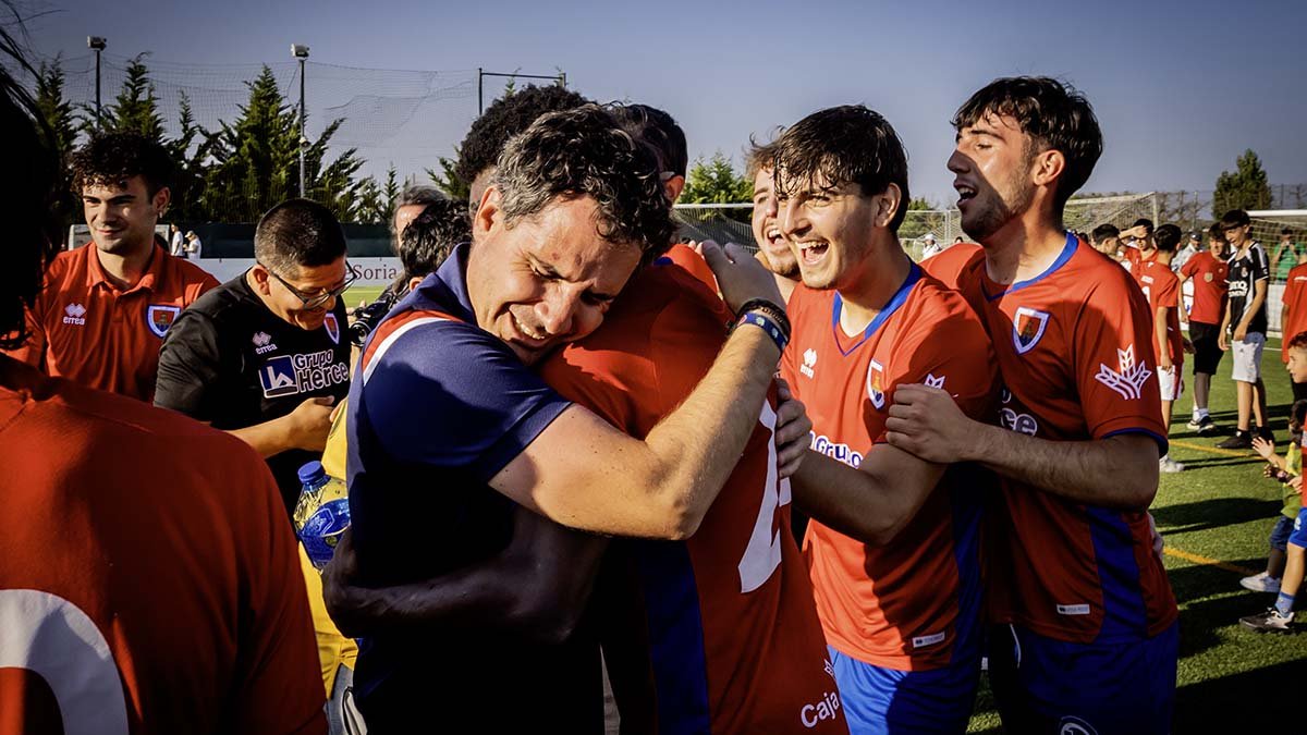 José Luis González se abraza a Godson en la celebración del ascenso a Tercera.