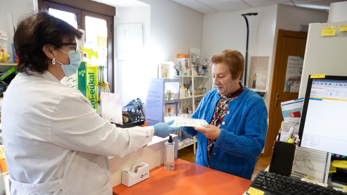 Usuaria recogiendo la medicación semanal en la farmacia rural de Valdeavellano, en Soria.