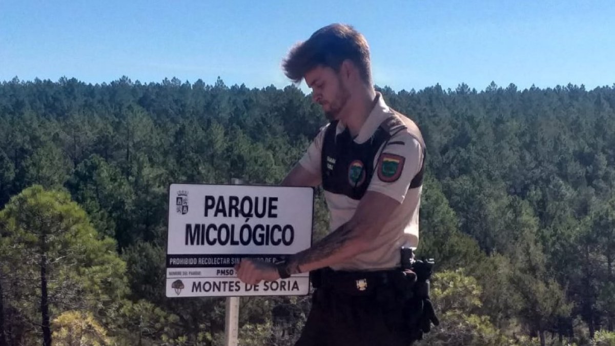Un guarda colocando un cartel del Parque Micológico Montes de Soria.