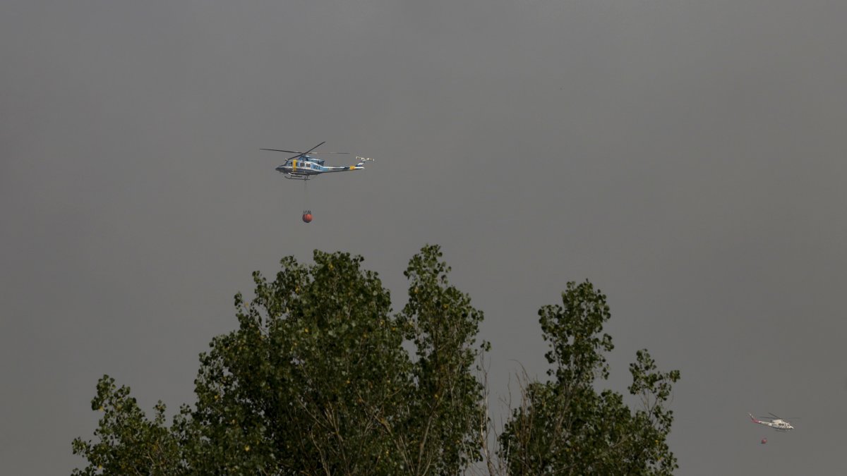 Helicóptero bombardero continúa con la tareas de extinción para sofocar el incendio forestal, a 17 de agosto de 2025, en Molinaferrera, León.