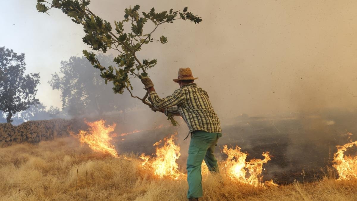 Un hombre apagando fuego.