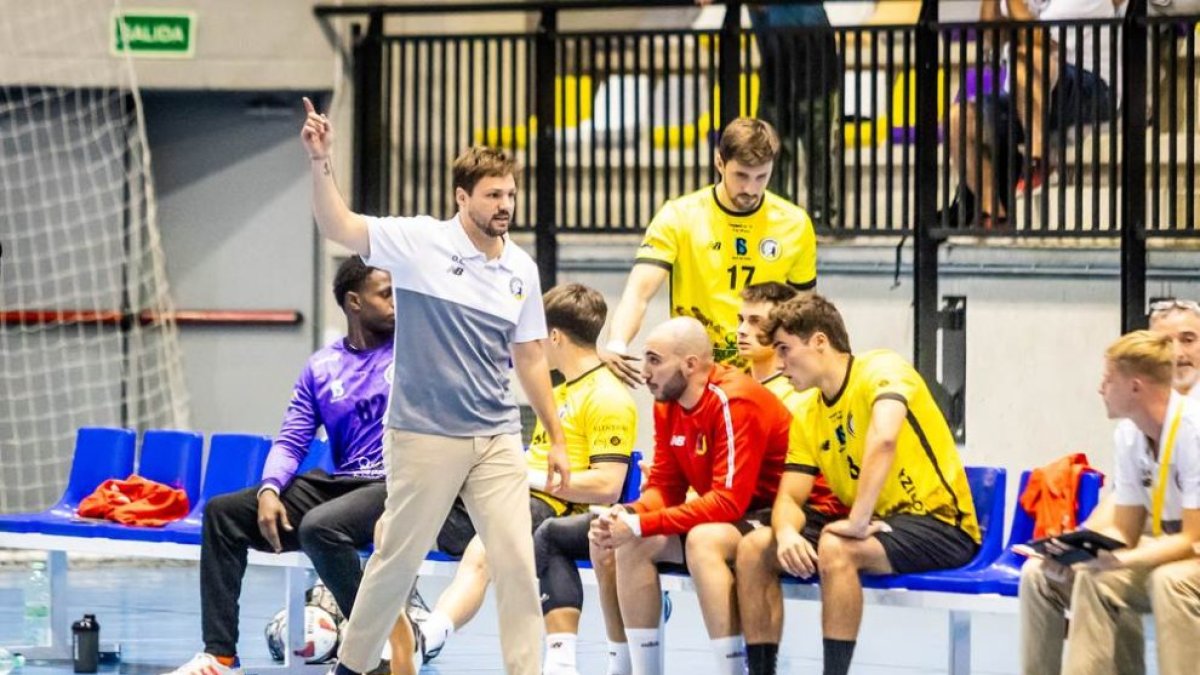 Sergio Sarasola en el banquillo del Balonmano Soria con sudadera roja.