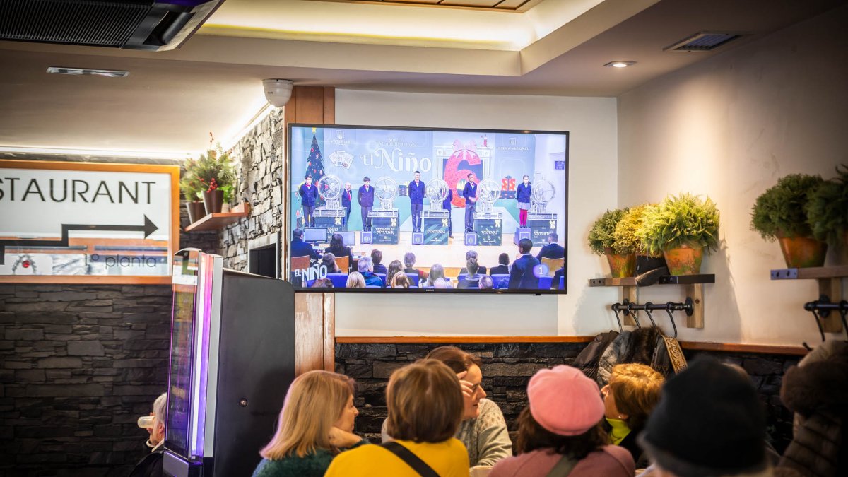 Personas siguiendo el sorteo en un bar de la capital.