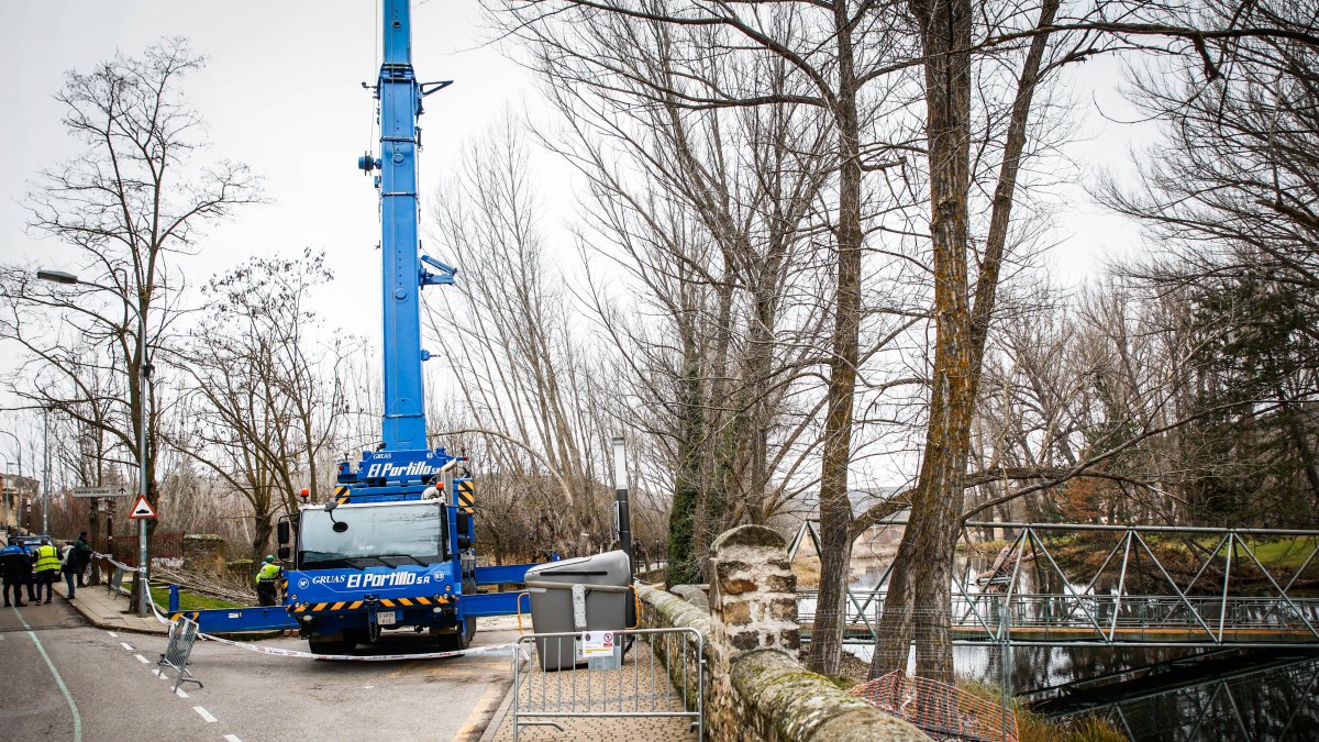 La grúa se posiciona en el paseo del Postiguillo para retirar la pasarela.