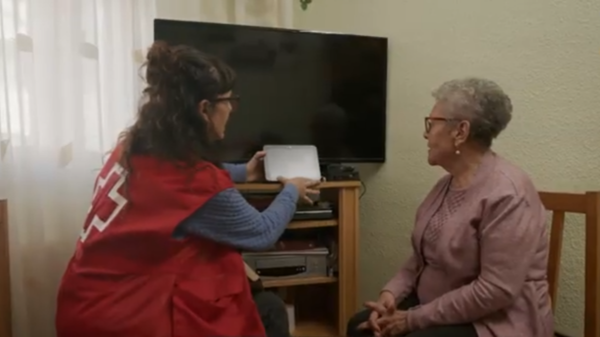 Voluntarios de Cruz Roja instalando uno de los asistentes virtuales para combatir la soledad de los mayores.