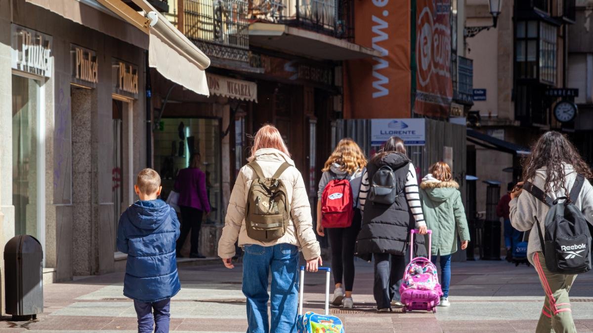 Personas con niños paseando por El Collado en Soria.