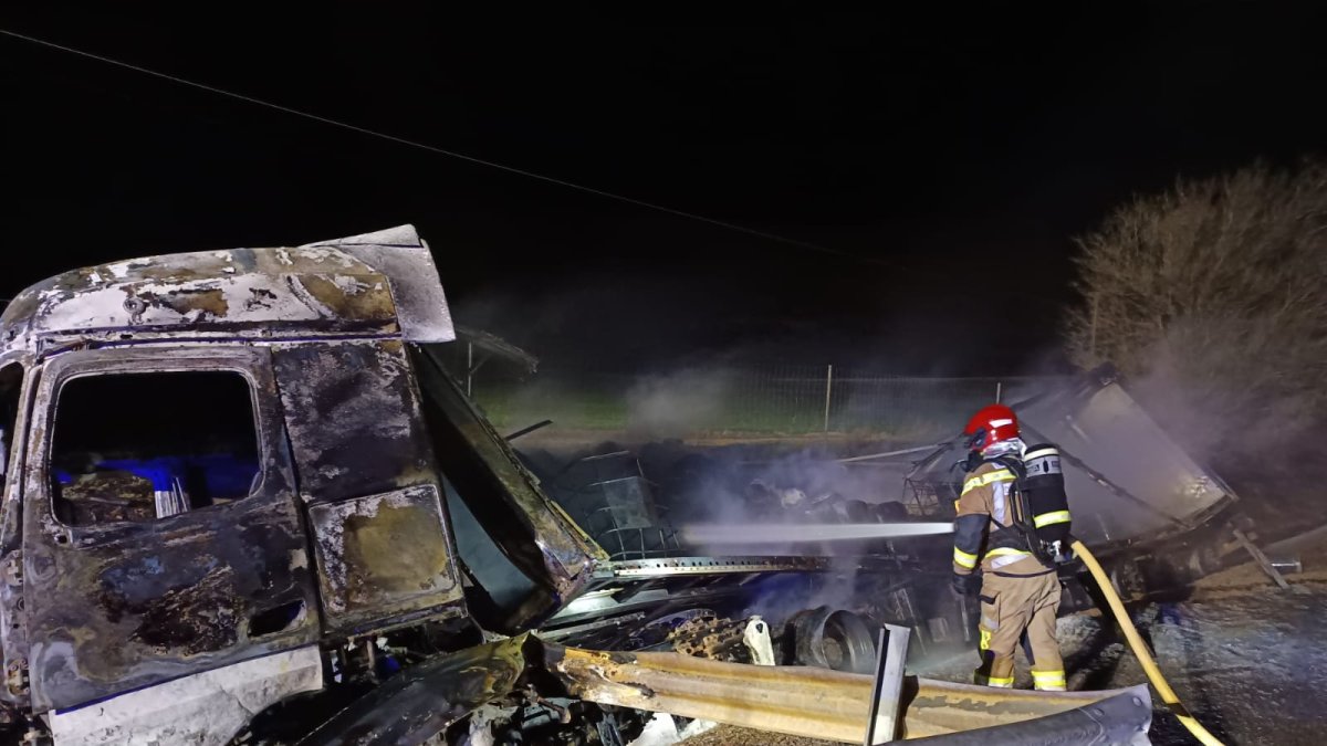 Un bombero trabaja para enfriar el camíón de mercancías peligrosas calcinado tras el accidente.