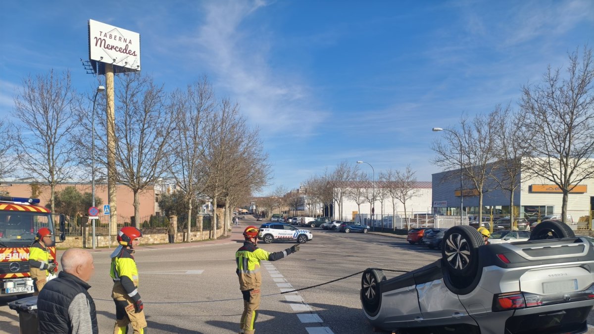 Los bomberos tratan de incorporar el coche volcado en el accidente de tráfico en Soria.