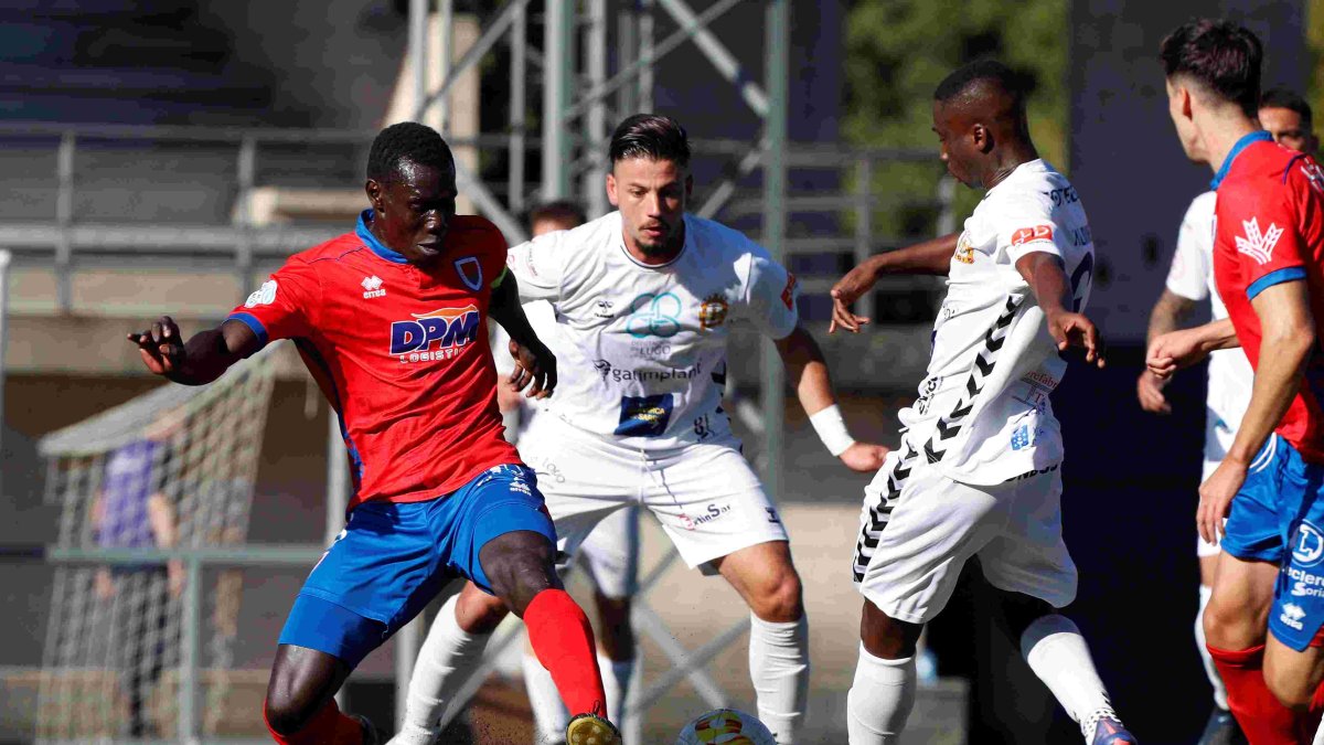 Moustapha pugna con dos jugadores de la Sarriana en el partido de la primera vuelta