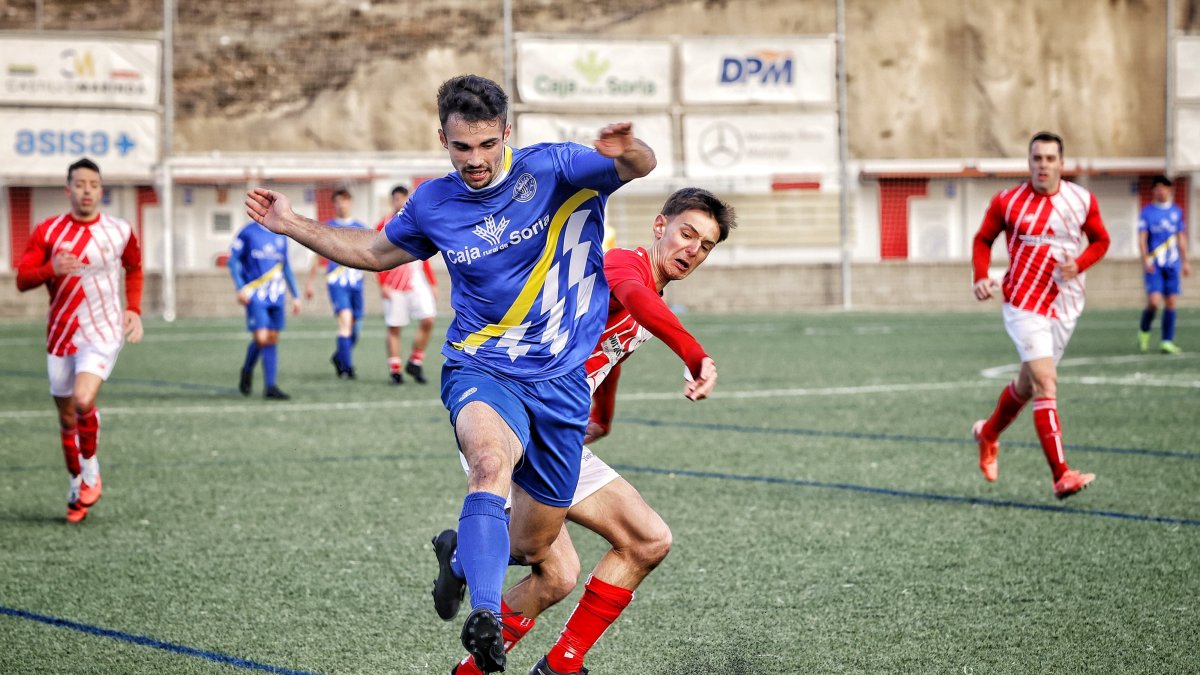 Un jugador del Calasanz se faja de un rival en una acción del partido.