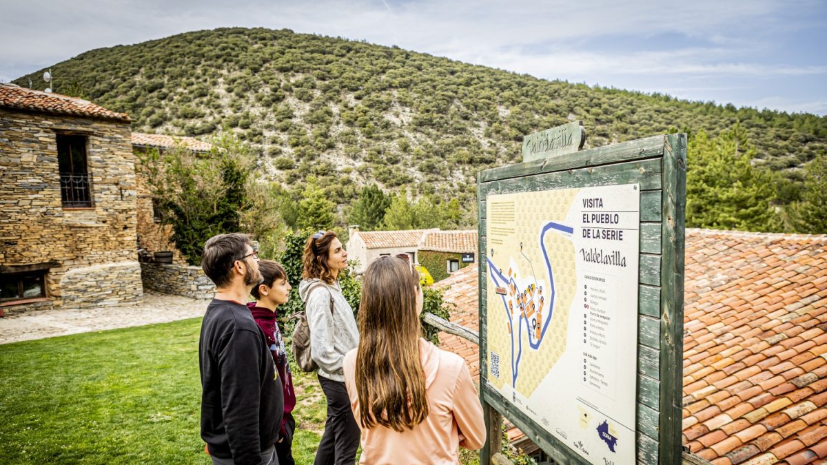 Una familia consulta el mapa de Valdelavilla, el pueblo de Soria que pasó de la despoblación a motor del turismo de calidad.