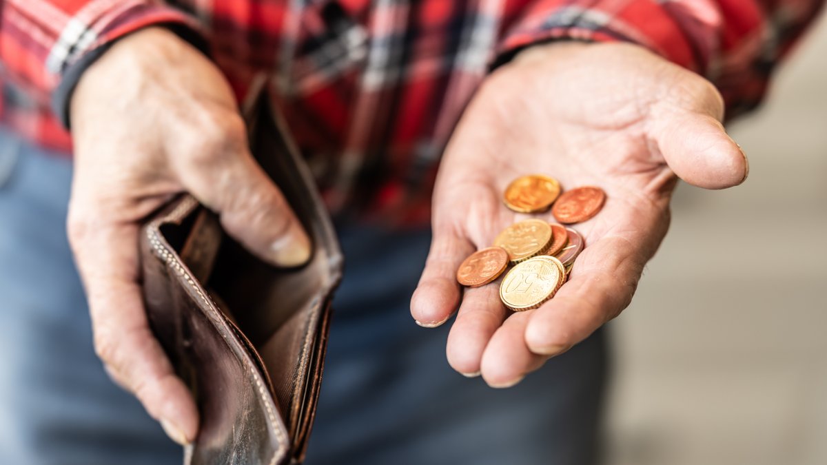 Un hombre sostiene en su mano un puñado de monedas