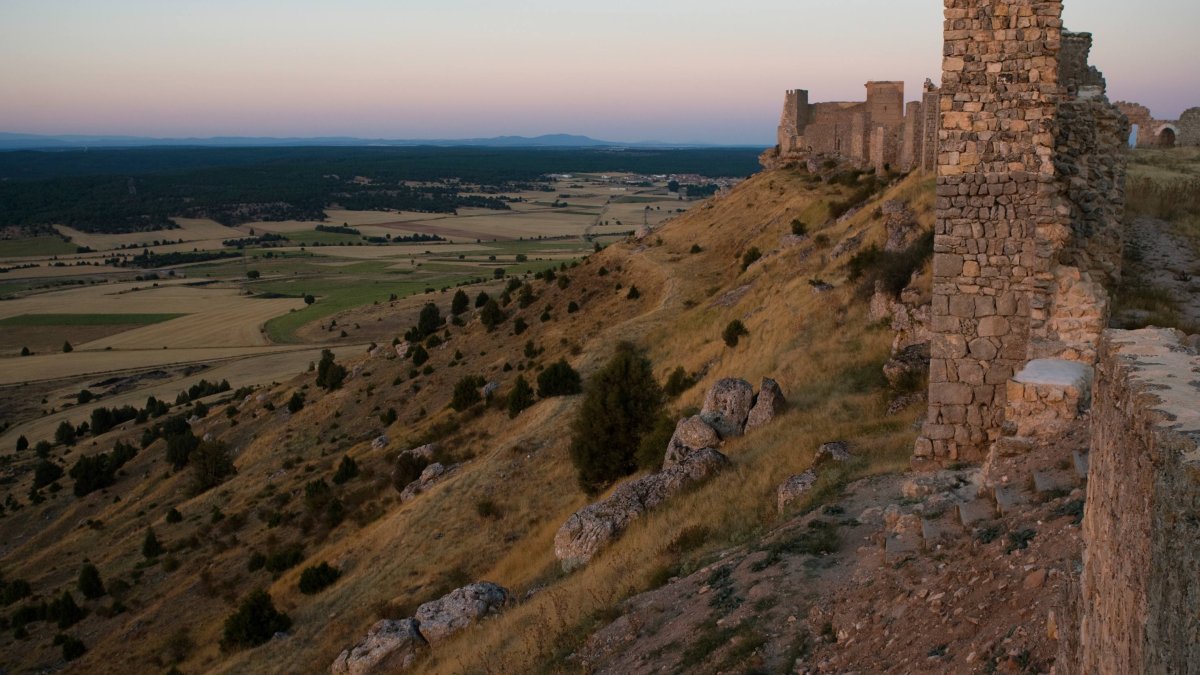 El Castillo de Gormaz se asoma al valle del Duero mientras el atardecer tiñe de tonos cálidos la meseta soriana