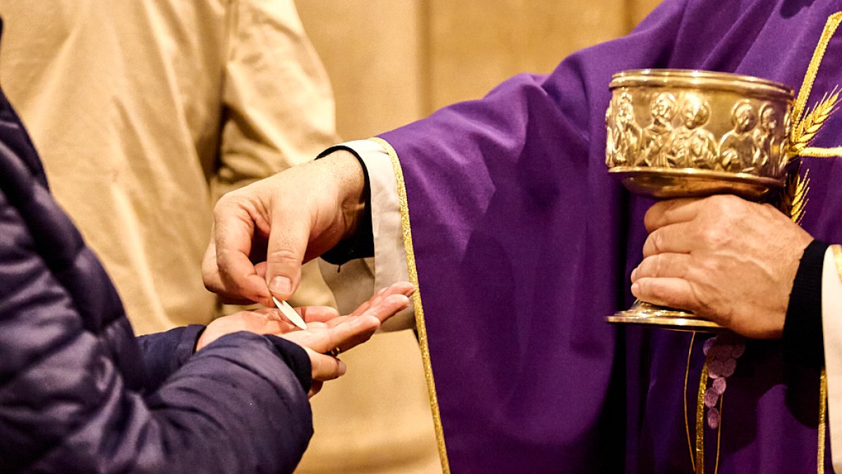 Un sacerdote dando la comunión a un feligrés en una imagen reciente.