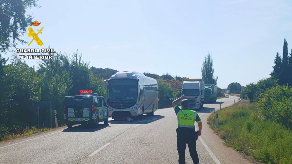 La Guardia Civil regula el tráfico ante el autobús implicado en el accidente.