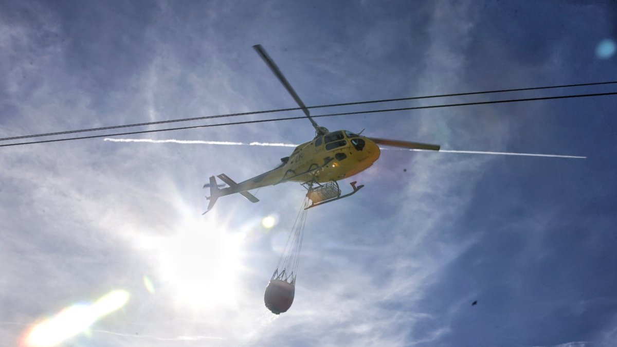 Un helicóptero con una carga de agua participa en la extinción del incendio de Tardelcuende declarado este miércoles.