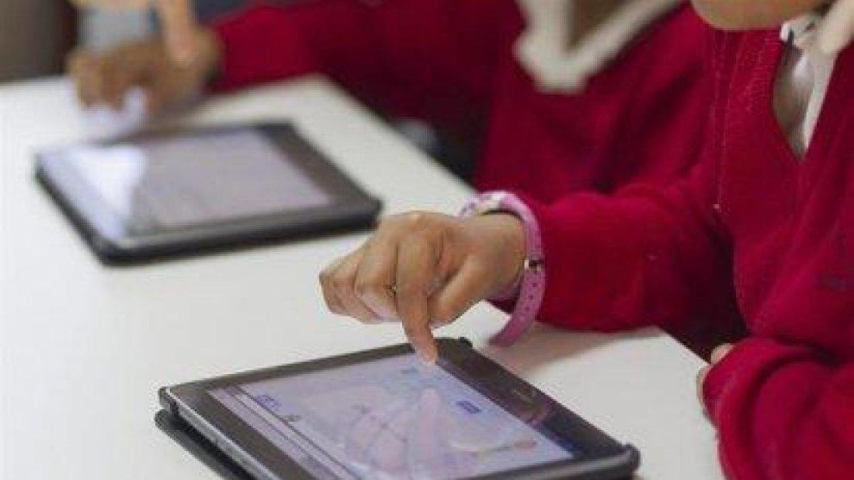 Alumnos emplean tablets en una clase.