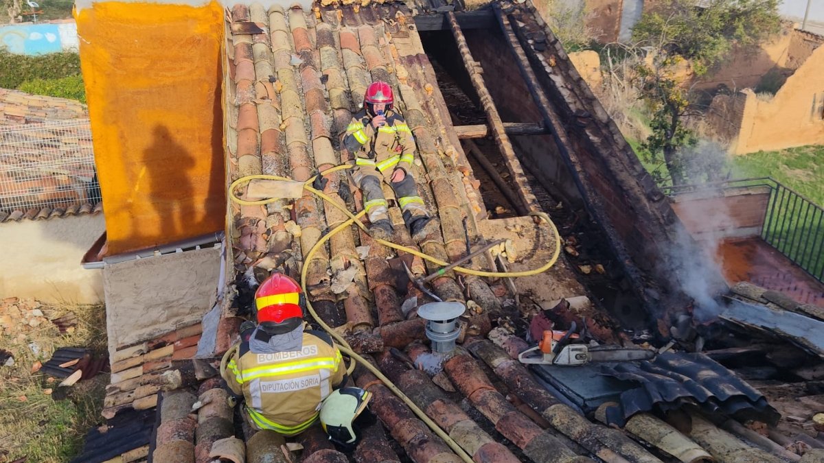 Los bomberos intervienen en el tejado afectado por el incendio.