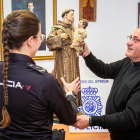 El párroco del Espino recibe la talla de manos de una policía. MARIO TEJEDOR