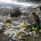 Un empleado trabaja con residuos en las instalaciones de la planta de tratamiento y selección de envases de Gavà, para su posterior reciclaje.-JOAN PUIG