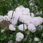 Las bolas de pedrisco de la tormenta comparadas con una moneda de euro.