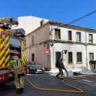 Los bomberos refrescan la zona tras apagar dos contenedores ardiendo en el barrio del Calaverón en la tarde del jueves festivo.