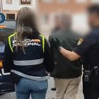 El detenido es conducido a un vehículo policial por dos agentes de la Policía Nacional.