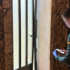 Un agente ante una de las viviendas de Barahona en la que destrozaron la puerta de entrada.