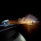 Los bomberos intentan apagar el incendio del tráiler cargado de mercancías peligrosas tras sufrir un accidente.