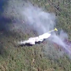 Un avión descarga sobre la zona del incendio forestal en Vinuesa.