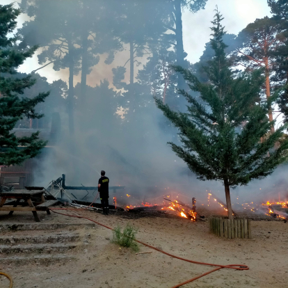 Las llamas aún vivas reducen a cenizas el chiringuito durante el incendio.