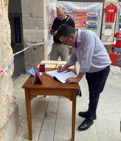 El presidente del Numancia, Patricio de Pedro, firma en el libro de visitas de la muestra.