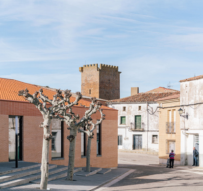 La combinación de ladrillo, vidrio y teja permite que el nuevo teleclub conviva con el patrimonio histórico y la vida cotidiana del pueblo.
